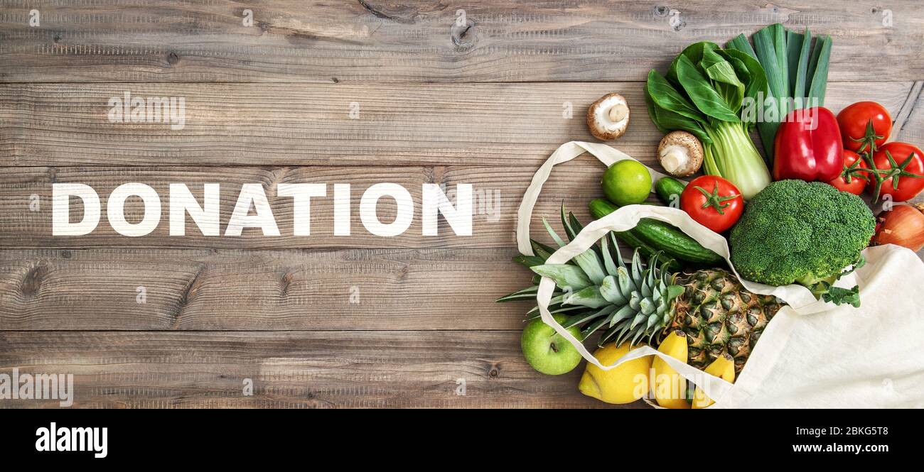 Lebensmittelspende. Gesunde Ernährung Obst Gemüse in Koton Beutel auf Holzhintergrund Stockfoto