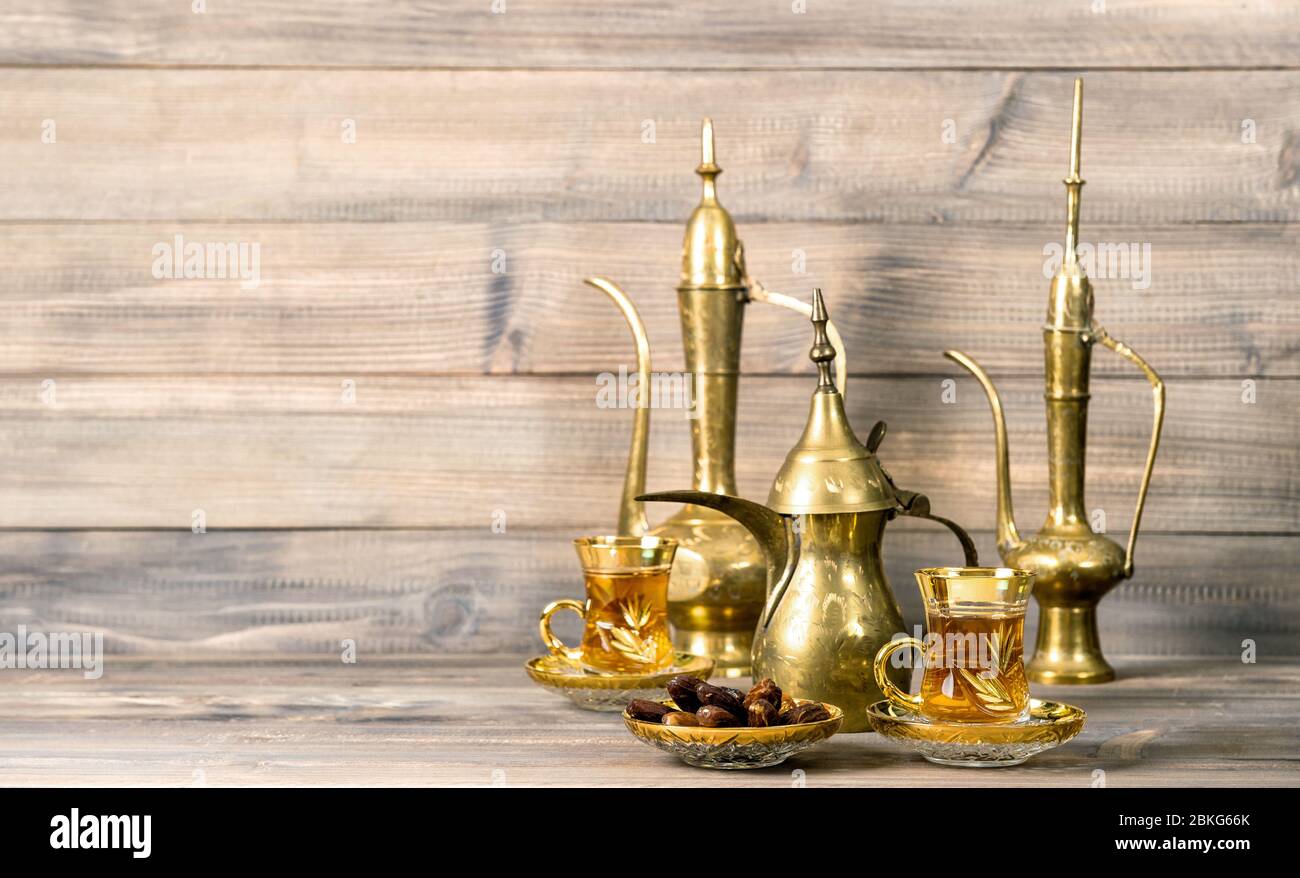 Orientalischer Teetafel mit Datteln und goldener Dekoration auf Holzhintergrund Stockfoto