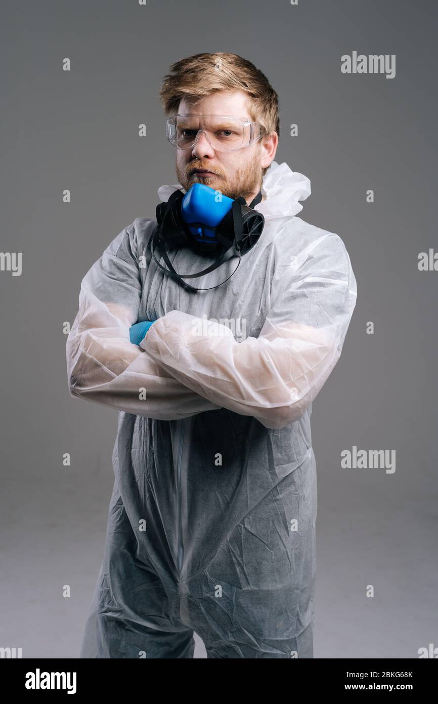 Ernsthafter Epidemiologe in Schutzhüllen, Brillen und Atemschutzgeräten. Stockfoto