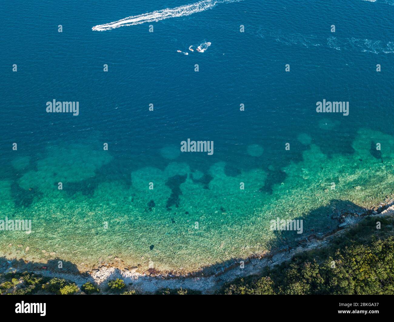 Luftaufnahme eines Wasserfahrzeugs, zerklüftete und üppige Küsten. Mediterranes Peeling. Meer, kristallklares Wasser. Sveti Nikola, Budva, Montenegro Stockfoto