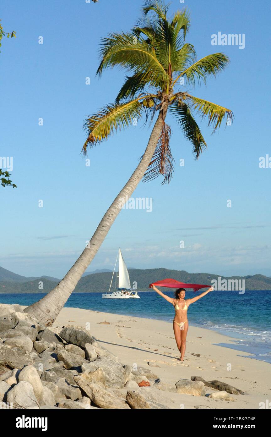 Frau an Palmenstrand, Segelboot im Hintergrund, Indischer Ozean Stockfoto