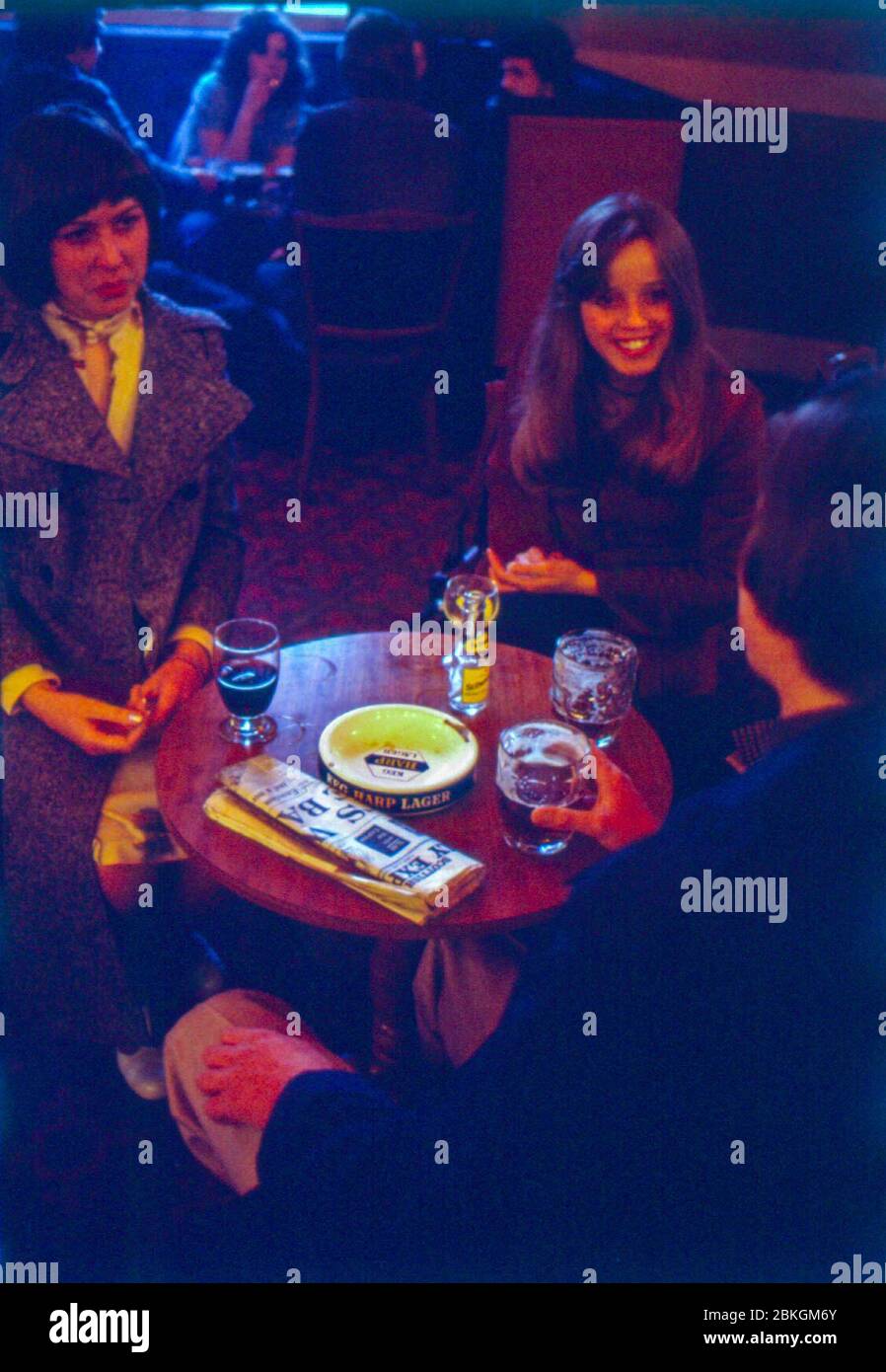 Leute, die in den 1970er Jahren in einem Londoner Pub einen Drink genießen Stockfoto