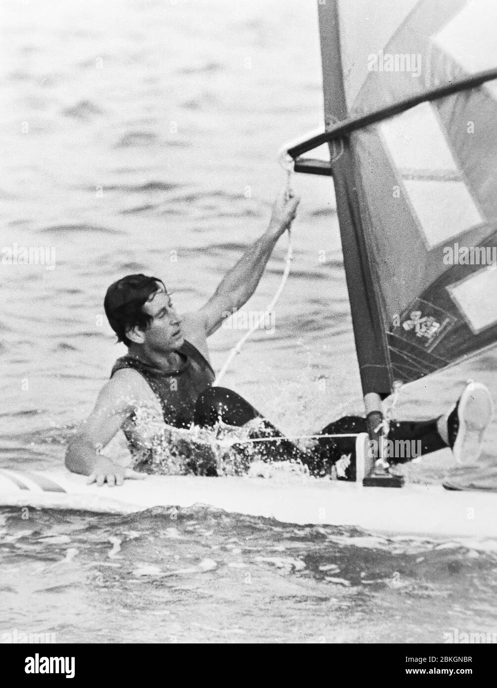 Prince Charles fällt in der Cowes Week vom 1980. Juli von seinem Windsurf ab Stockfoto