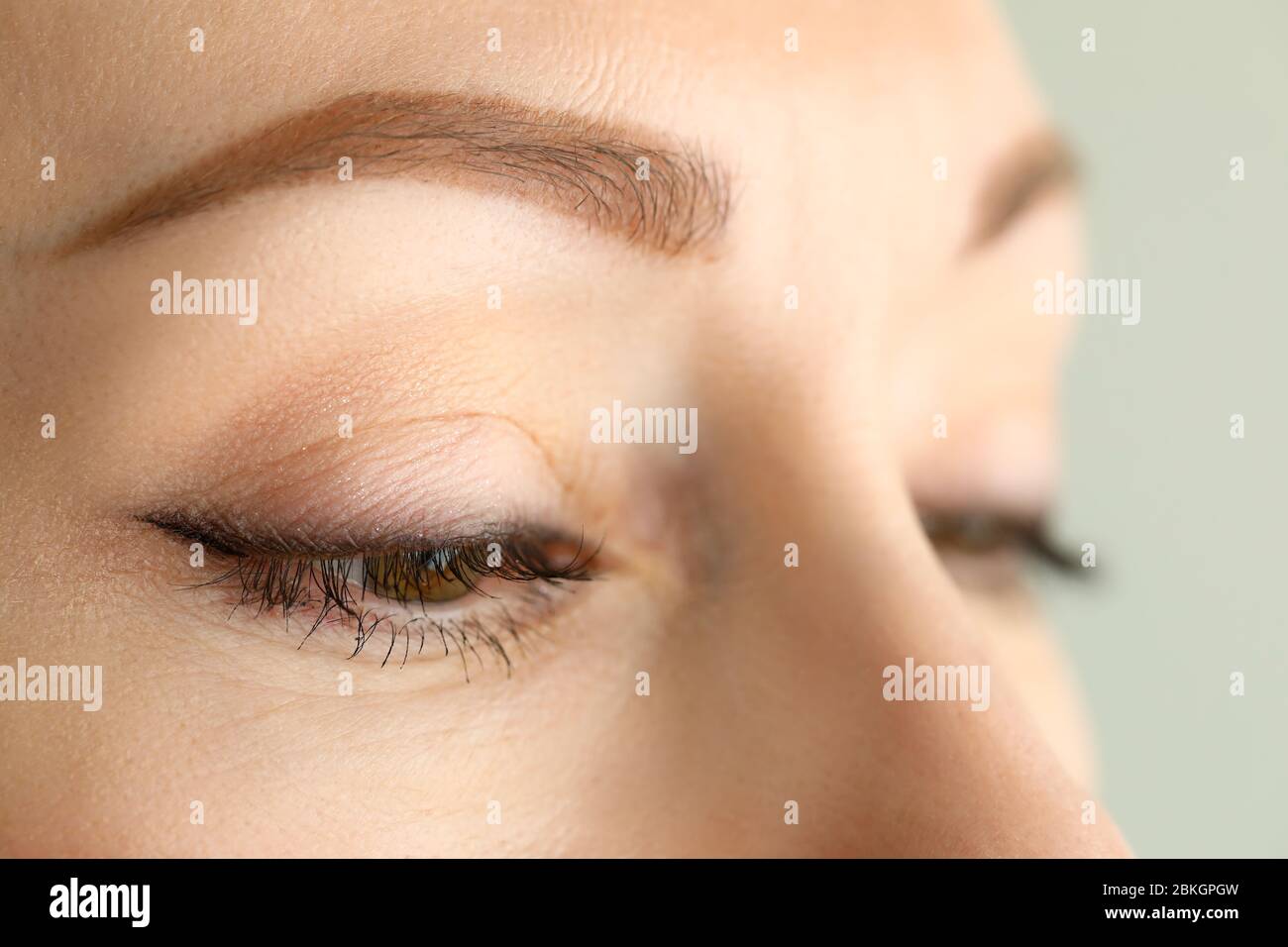 Orange-grün-farbige weibliche, erstaunliche halbgeöffnete Augen Stockfoto