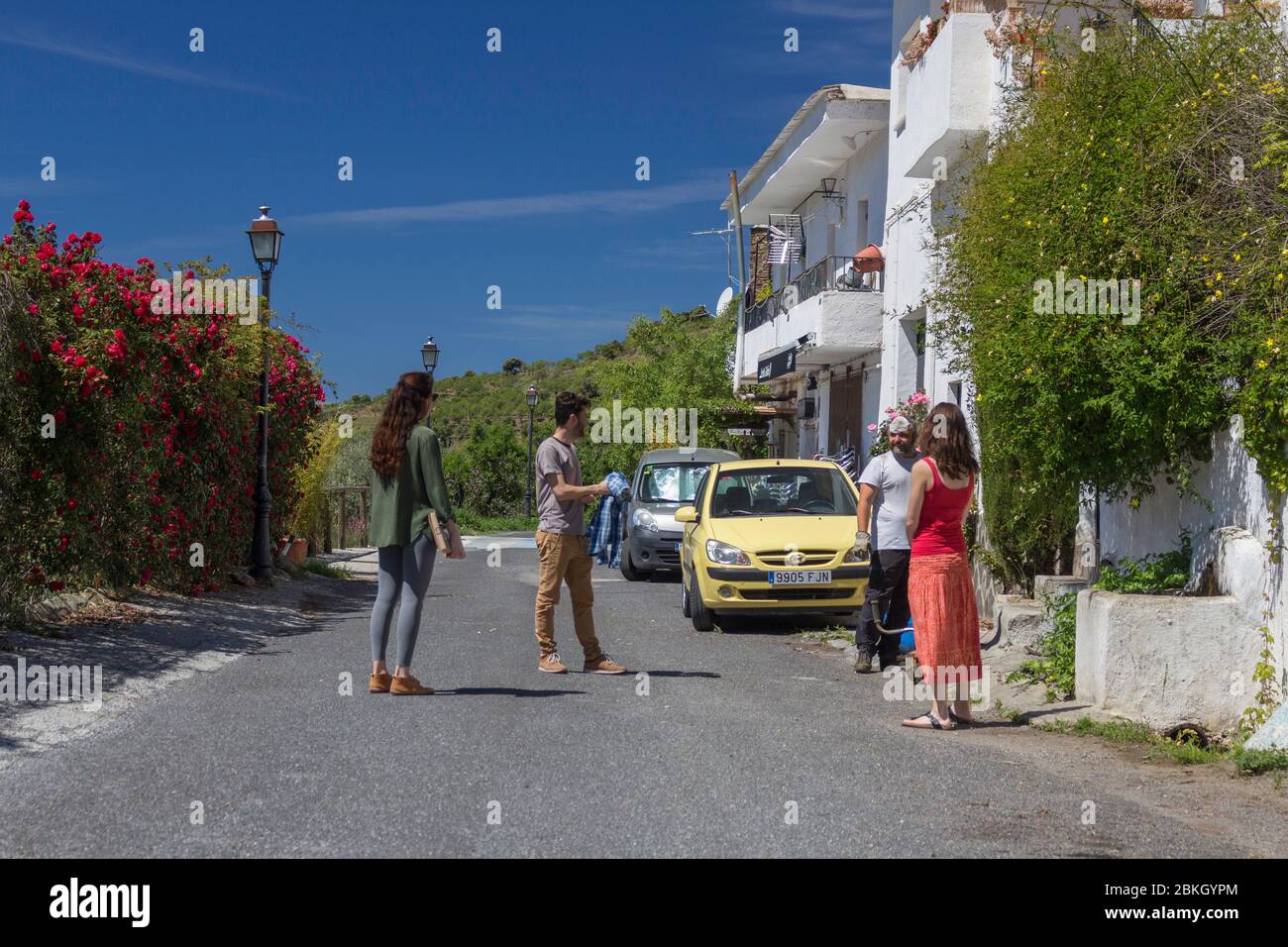 GRANADA, SPANIEN - 4. MAI 2020: Freunde, die an der Straße entlang gehen, respektieren die Distanz, die sie zurücklegen müssen, während Spanien reibungslos öffnet Stockfoto