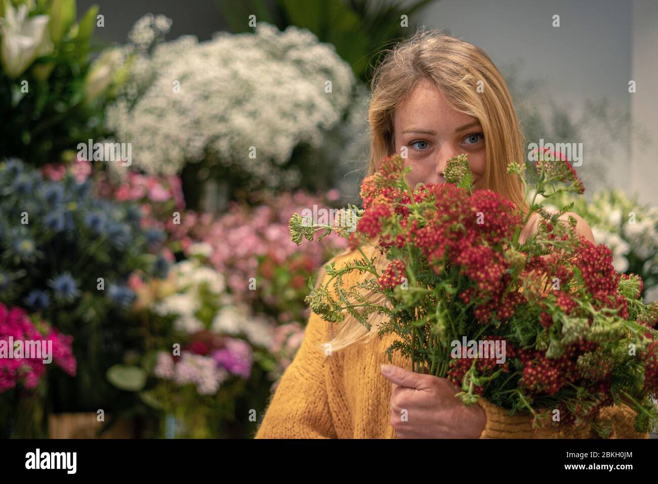 Junge Frau im Blumenladen stehend Stockfoto
