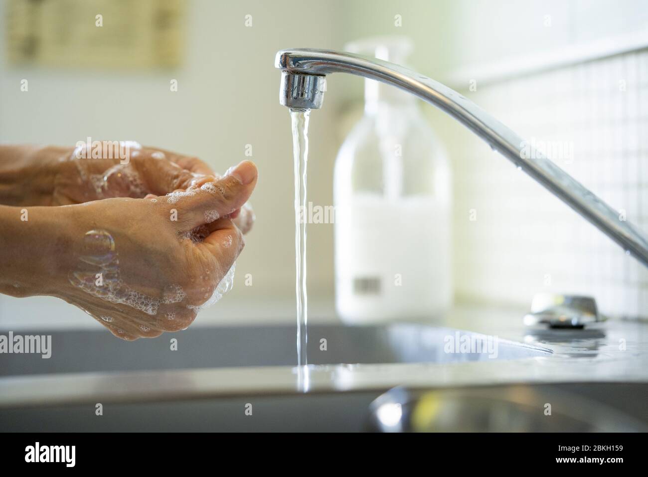 Mann, der sich die Hände mit Seife im Waschbecken wäscht Stockfoto