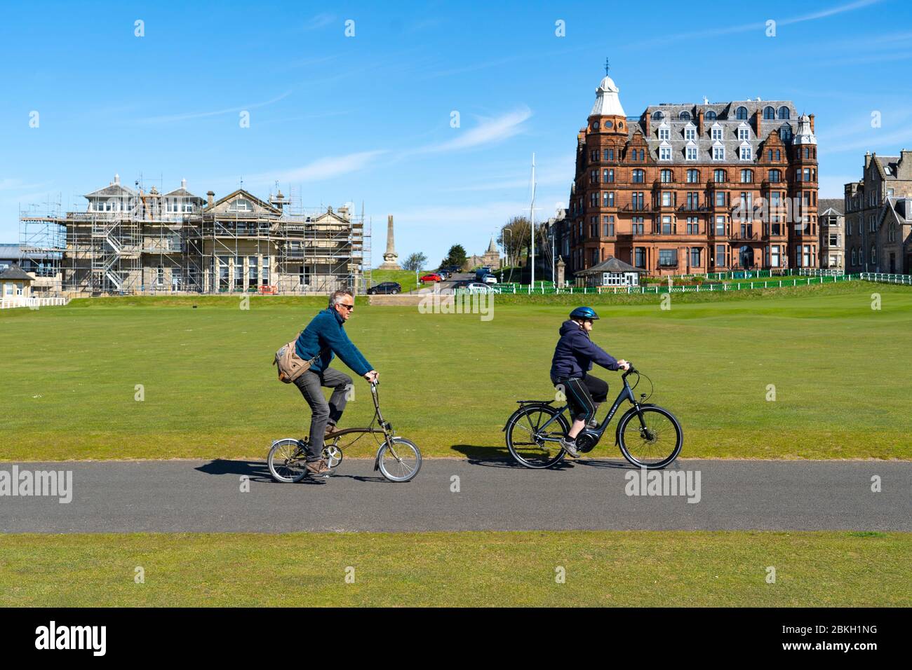 St Andrews, Schottland, Großbritannien. Mai 2020. Der berühmte Old Course in St Andrews ist wegen der Sperrung des Coronavirus geschlossen. Die Einheimischen nutzen den geschlossenen Golfplatz optimal, indem sie ihn als Park für ihre täglichen Übungen nutzen. Paar radeln auf dem Weg über die erste und achtzehn Fairways. Iain Masterton/Alamy Live News Stockfoto