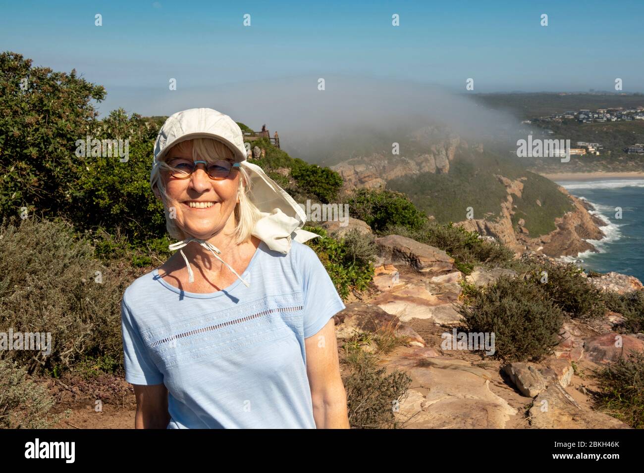 Südafrika, Western Cape, Plettenberg Bay, Robberg Nature Reserve, Senior Tourist auf Küstenwanderweg, als der Nebel im Meer hereinrollt Stockfoto