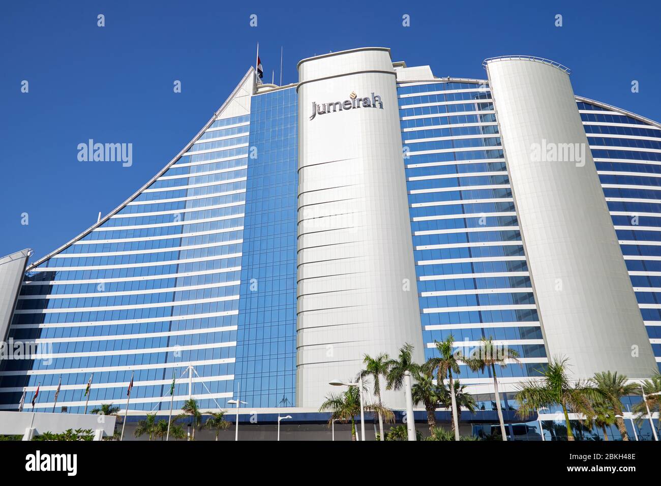 DUBAI, VEREINIGTE ARABISCHE EMIRATE - 22. NOVEMBER 2019: Jumeirah Beach Luxushotel mit Palmen an einem sonnigen Tag, blauer Himmel in Dubai Stockfoto