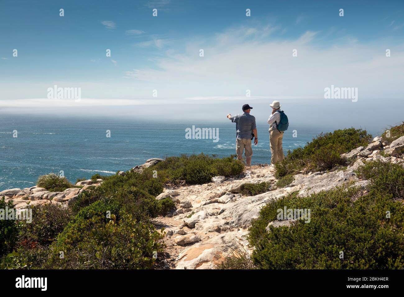 Südafrika, Western Cape, Plettenberg Bay, Robberg Nature Reserve, Cape Seal, Senioren Touristen ruhen auf Küstenwanderweg über felsigen Küste Stockfoto