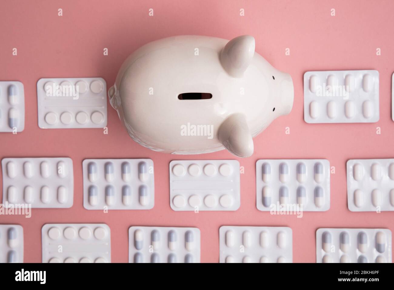 Kosten für das Gesundheitswesen. Spardose Sparschwein mit Päckchen Pillen und Tablet Stockfoto