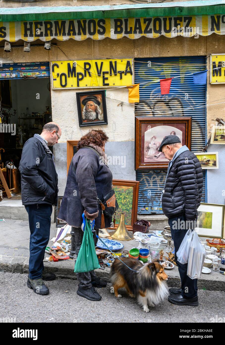 Schnäppchenjäger stöbern in den Antiquitäten und dem Brocken, die auf dem Flohmarkt Rastro zwischen La Latina und Embajadores, Madrid, Spanien, verkauft werden. Stockfoto