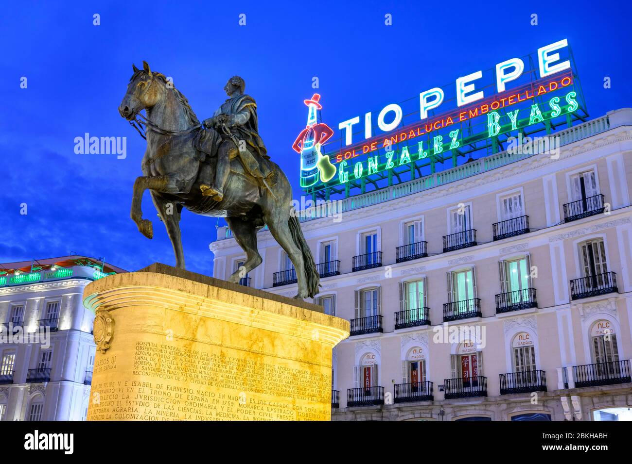 Das berühmte Tio Pepe Reklameschild erhebt sich über eine Statue von König Carlos III, an der Puerta del Sol, Madrid, Spanien. Stockfoto