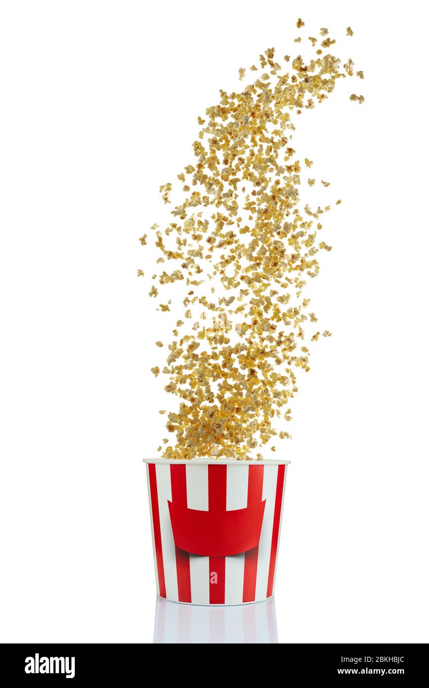 Fliegendes Popcorn aus rot-weißem Papier gestreifter Eimer isoliert über dem weißen Hintergrund. Popcorn im Kino Stockfoto