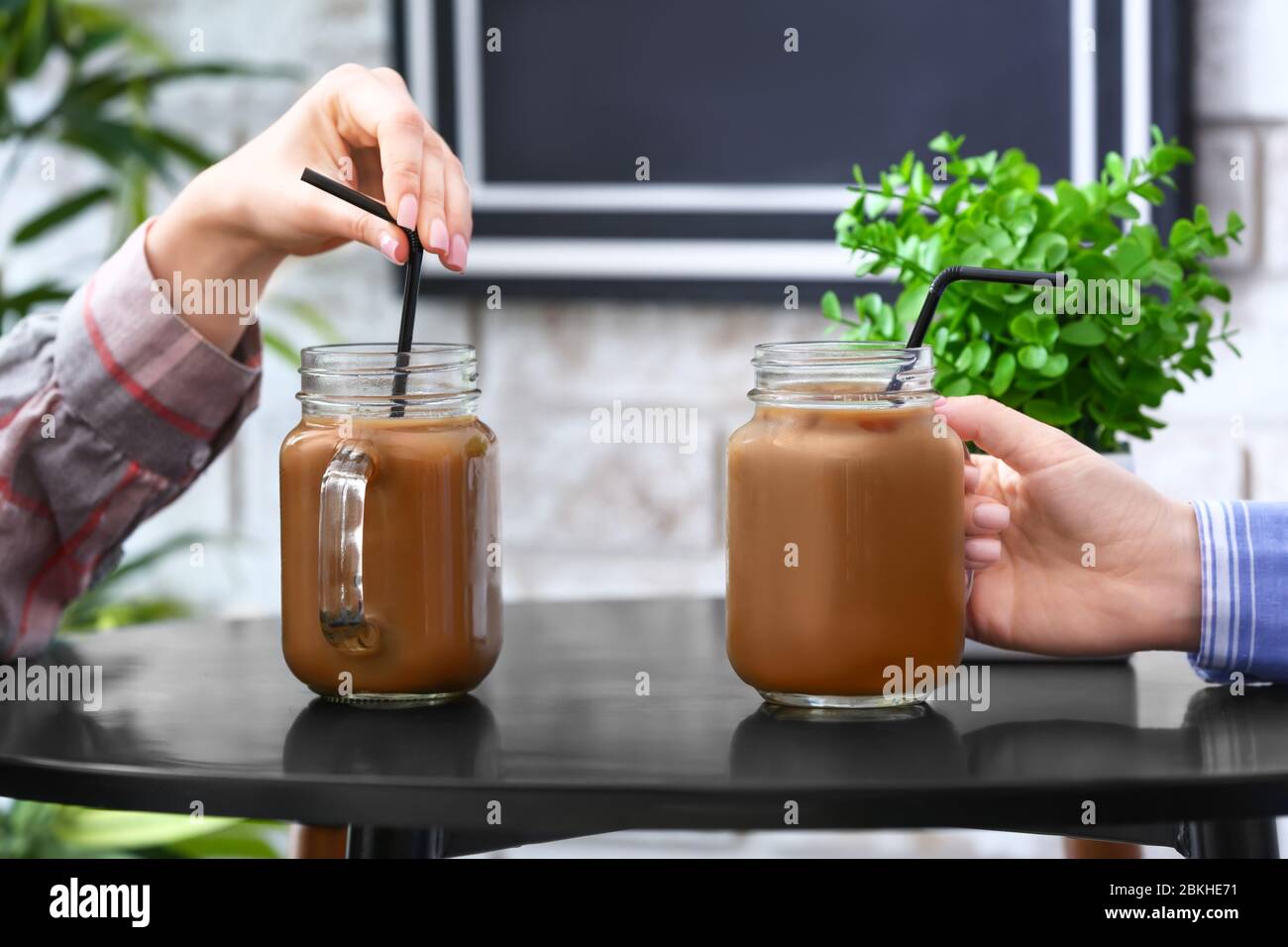Frauen mit Maurer Gläser von leckeren Eiskaffee im Café, Nahaufnahme Stockfoto