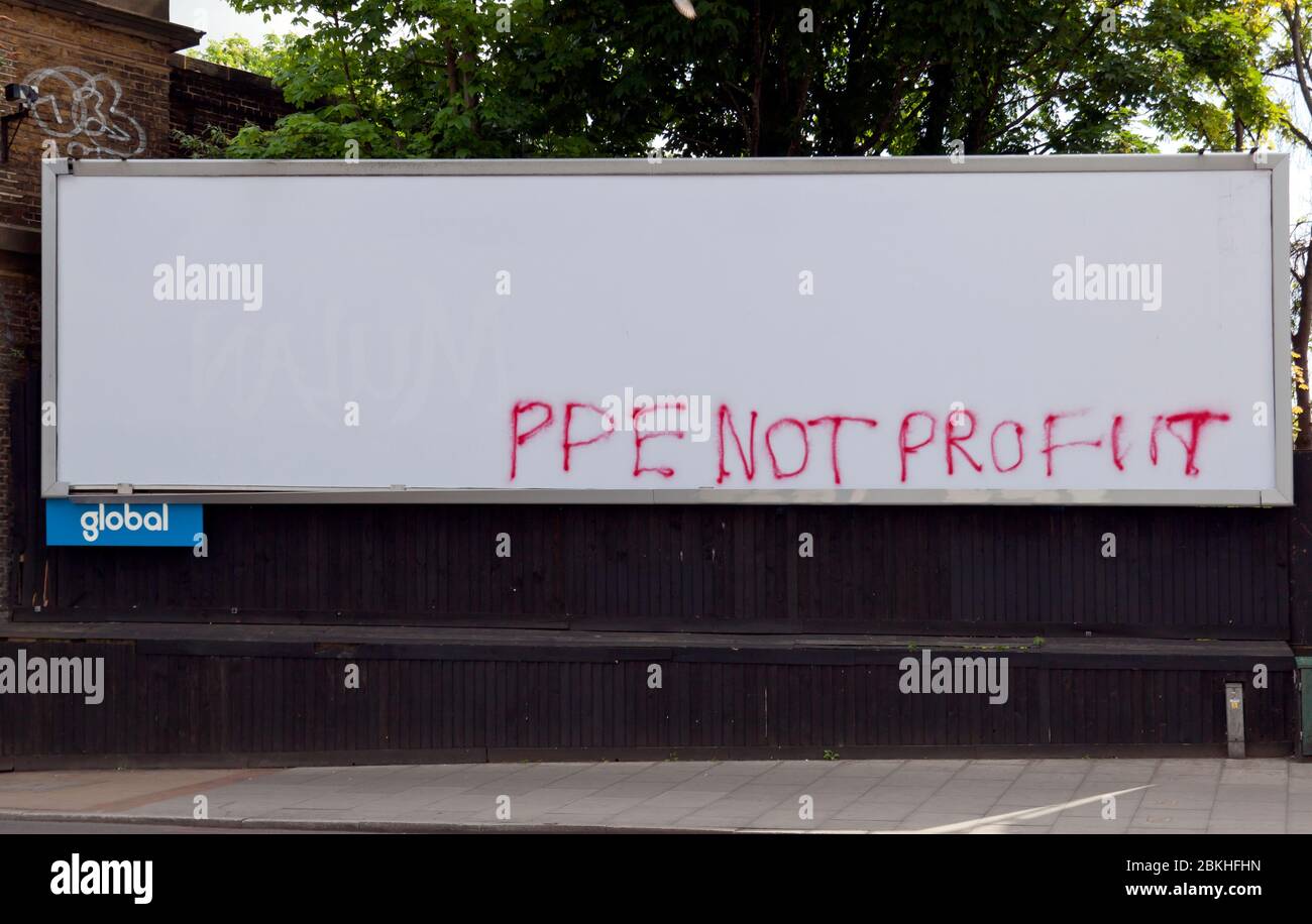 Nahaufnahme einer großen, leeren, globalen Werbepanel mit politischen Graffiti, die "PPE Not Profit" anführen, auf der Lewisham High Street während der COVID-19 Pandemie Stockfoto