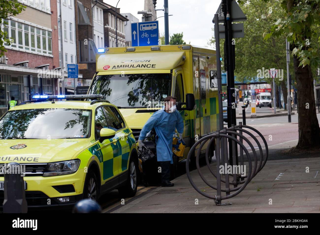 London Ambulance Crewmember, gekleidet in persönliche Schutzausrüstung, kommt in Lewisham Hight Street an, um während der COVID-19 Pandemie an einem medizinischen Notfall teilzunehmen Stockfoto