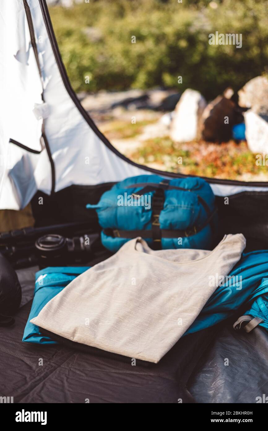 Gefaltete T-Shirts und Campingausrüstung in einem Zelt an einem sonnigen Tag Stockfoto