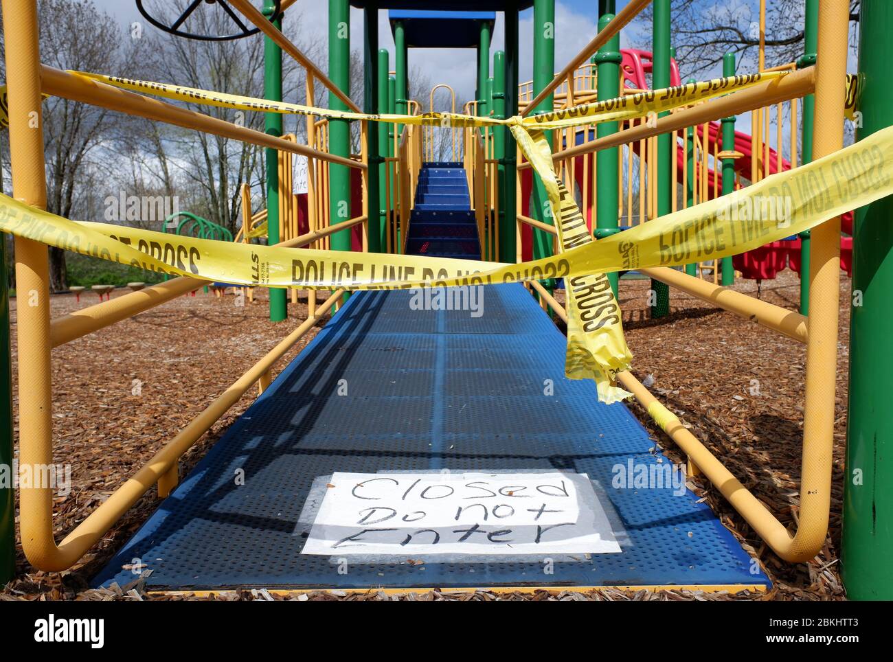 Geschlossen nicht betreten Zeichen mit Polizeilinie nicht überqueren Barrikaden Band umgeben eine Grundschule Spielplatzgeräte während der Sperrung von Covid-19, Coronavirus Pandemie in New Jersey.USA Stockfoto