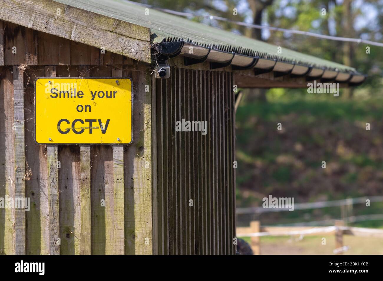 Lächeln Sie mit einem CCTV-Warnschild Stockfoto