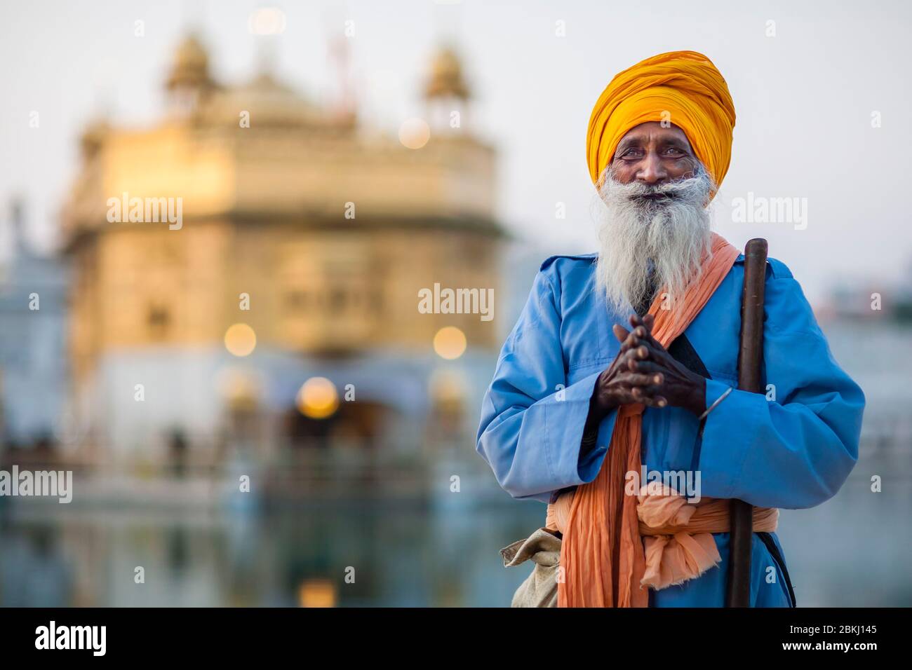 Indien, Punjab Staat, Amritsar, Harmandir Sahib, betend Porträt eines Sikh Mann mit einem durchdringenden Blick und Golden Temple im Hintergrund, heiliger Ort des Sikhismus Stockfoto