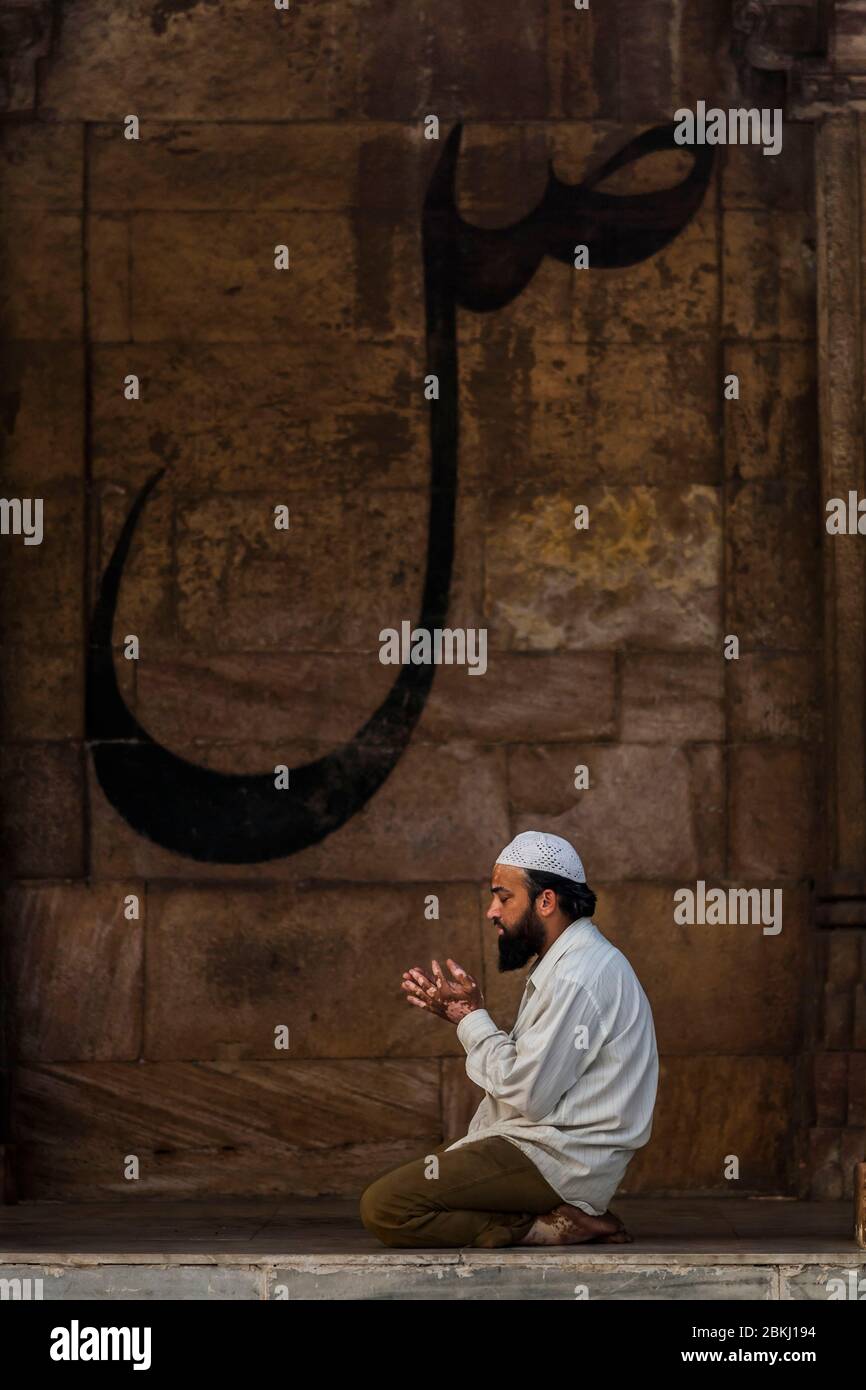 Indien, Gujarat Staat, Ahmedabad, Jami Masjid, große Moschee, muslimischer Mann, der vor arabischer Kalligraphie betet Stockfoto