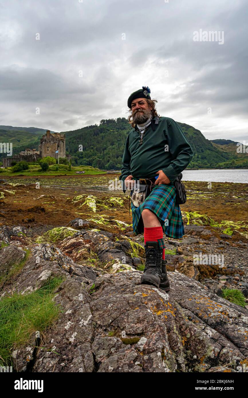 Großbritannien, Schottland, Highlands, Ross & Cromarty County, Dornie, Eilean Donan Castle am Eingang zum Loch Duich, schottischer Reiseführer in Kilt Stockfoto