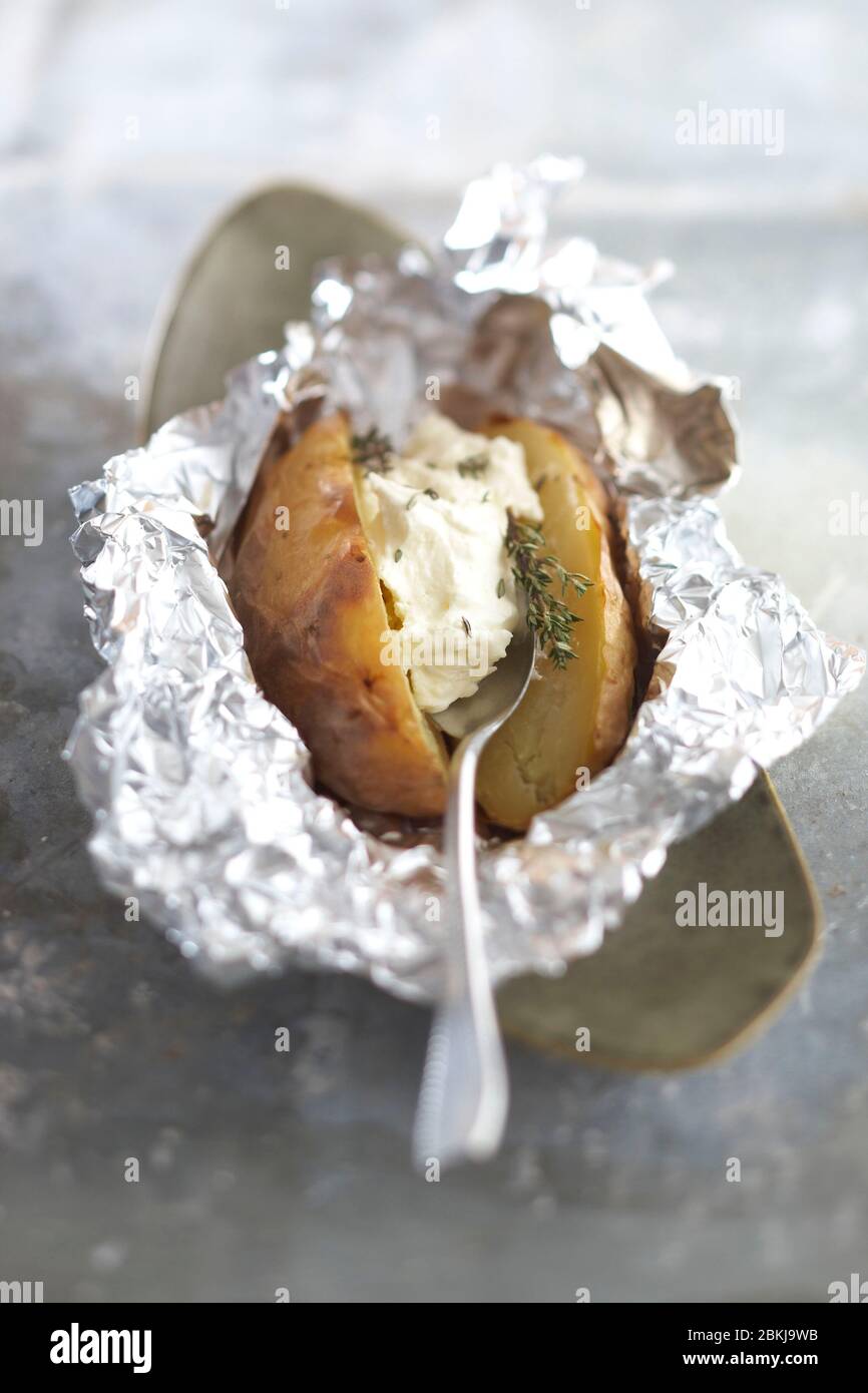 Geröstete Kartoffeln in Feldkleid mit Schlagsahne und Thymian Stockfoto