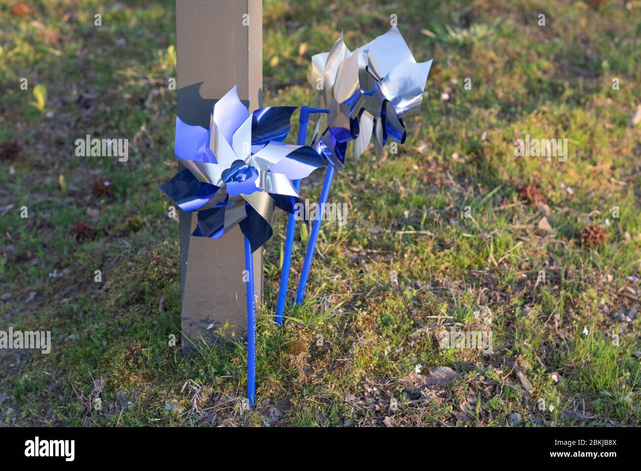 Zwei blaue und silberne Pinwheels haben sich zum Thema nationaler Monat der Kindesmisshandlung in einem örtlichen Militärgemeinschaftszentrum aufgemacht. Stockfoto
