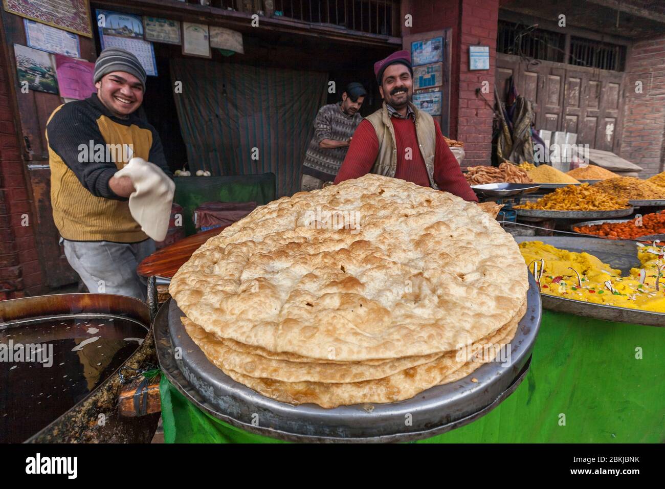 Indien, Jammu und Kaschmir, Charar-i-sharief, Nahaufnahme auf den großen gebratenen Pfannkuchen, die von einem Koch zubereitet werden Stockfoto