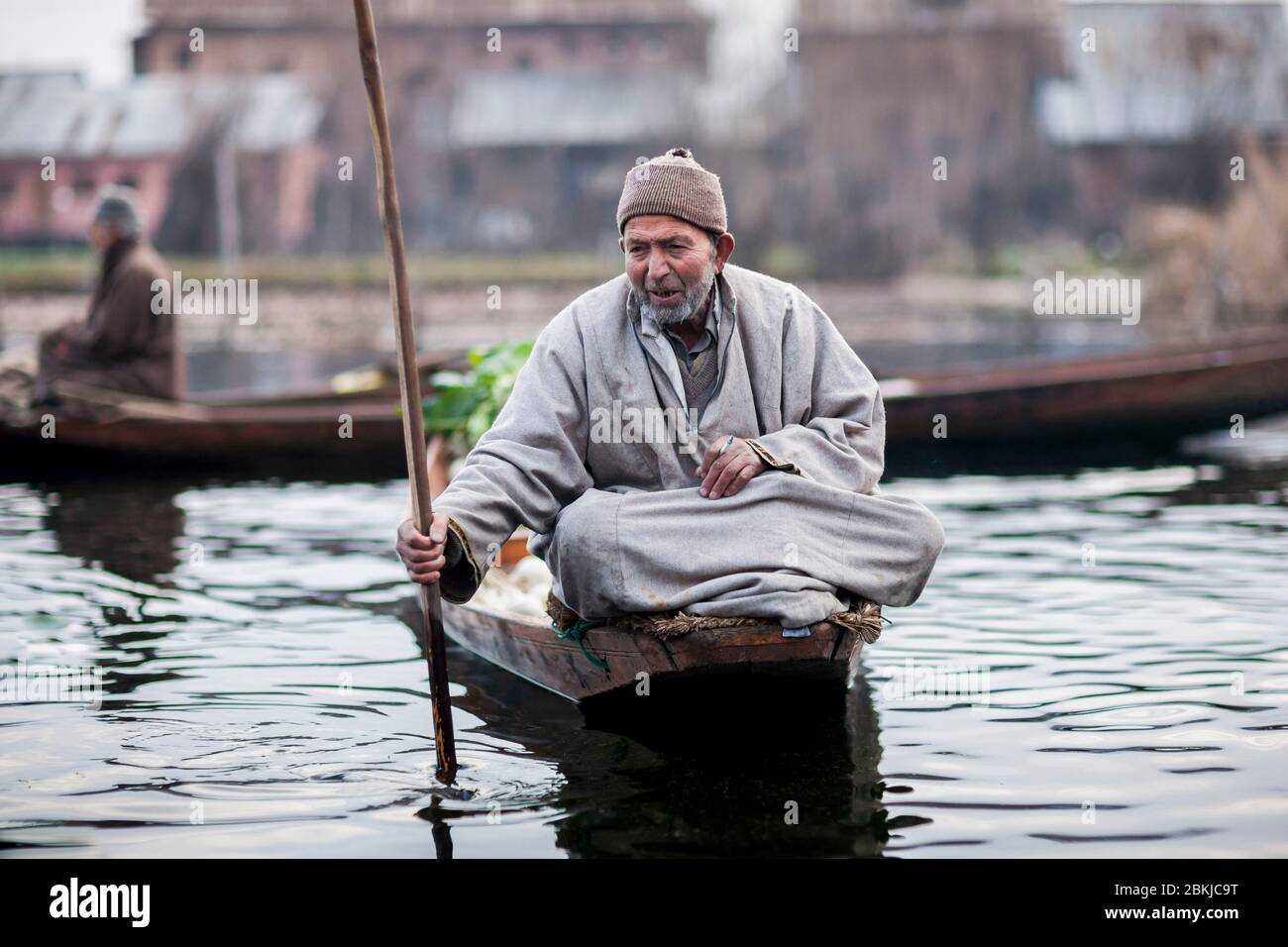 Indien, Jammu und Kaschmir, Srinagar, Dal See, schwimmende Gemüsemarkt, Mann auf einem Shikara, Kashmiri Pirogue, und das Tragen eines Pheran, traditionelle Wollponcho Stockfoto