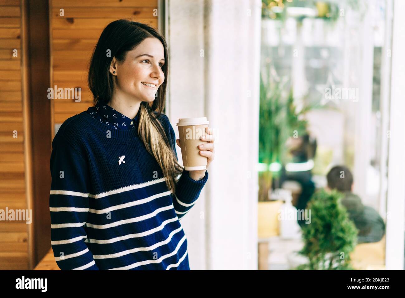 Mädchen mit einer Einweg-Tasse Kaffee Stockfoto