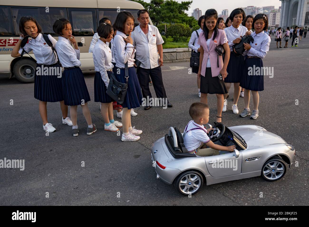 Nordkorea, Pjöngjang, Kind, das mit einem BMW-Wagen vor dem Triumphbogen spielt Stockfoto