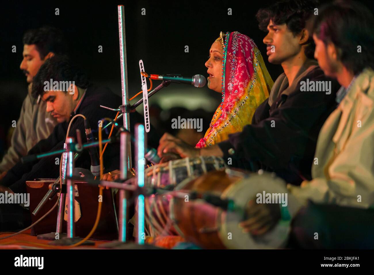 Indien, Rajasthan, Bikaner, Kamel Festival, Sängerin trägt einen Sari, sitzt neben ihren Musikern Stockfoto