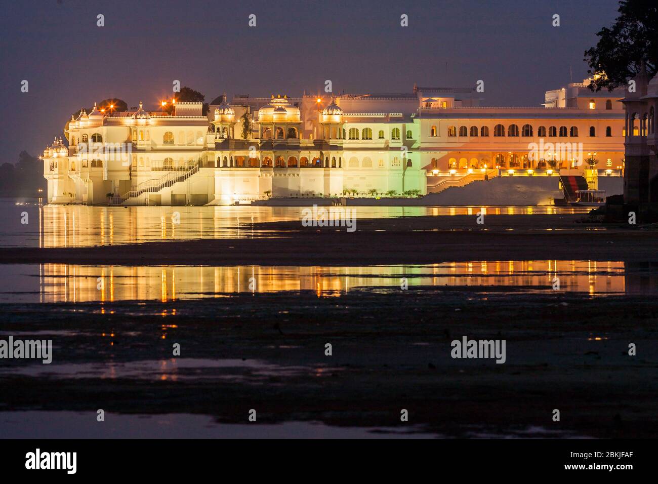 Indien, Rajasthan, Udaipur, Nacht Blick auf Luxus-Hotel Lake Palace auf Jag Niwas Insel und Reflexion auf dem Pichola-See Stockfoto