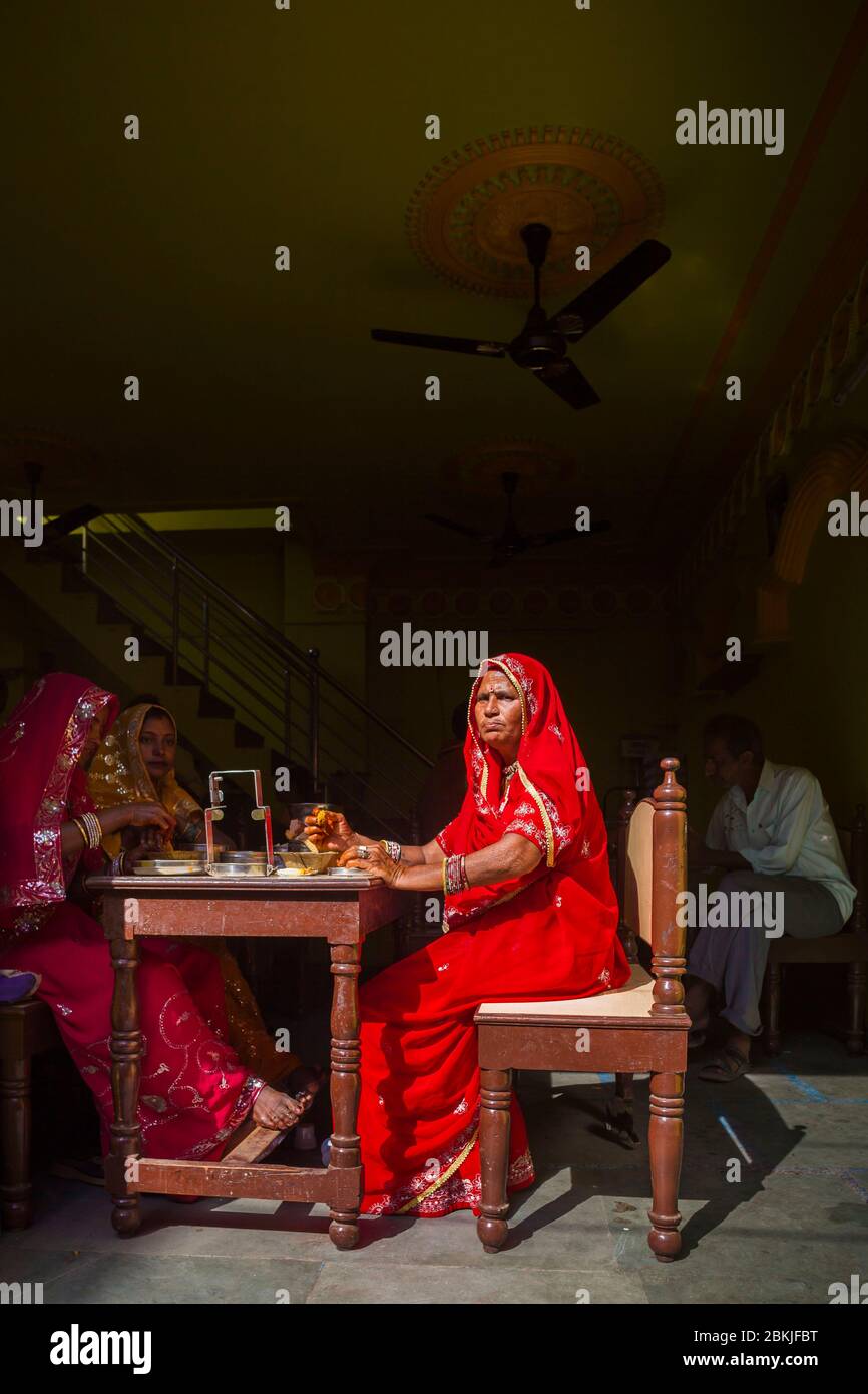 Indien, Rajasthan, Pushkar, ältere Frau in roten Sari sitzen am Tisch eines Restaurants Stockfoto