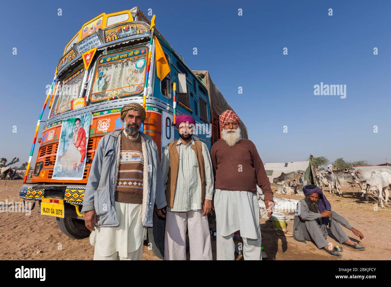 Indien, Rajasthan, Nagaur, Viehmarkt, Gruppe von Kamelhändlern vor einem bunten LKW Stockfoto