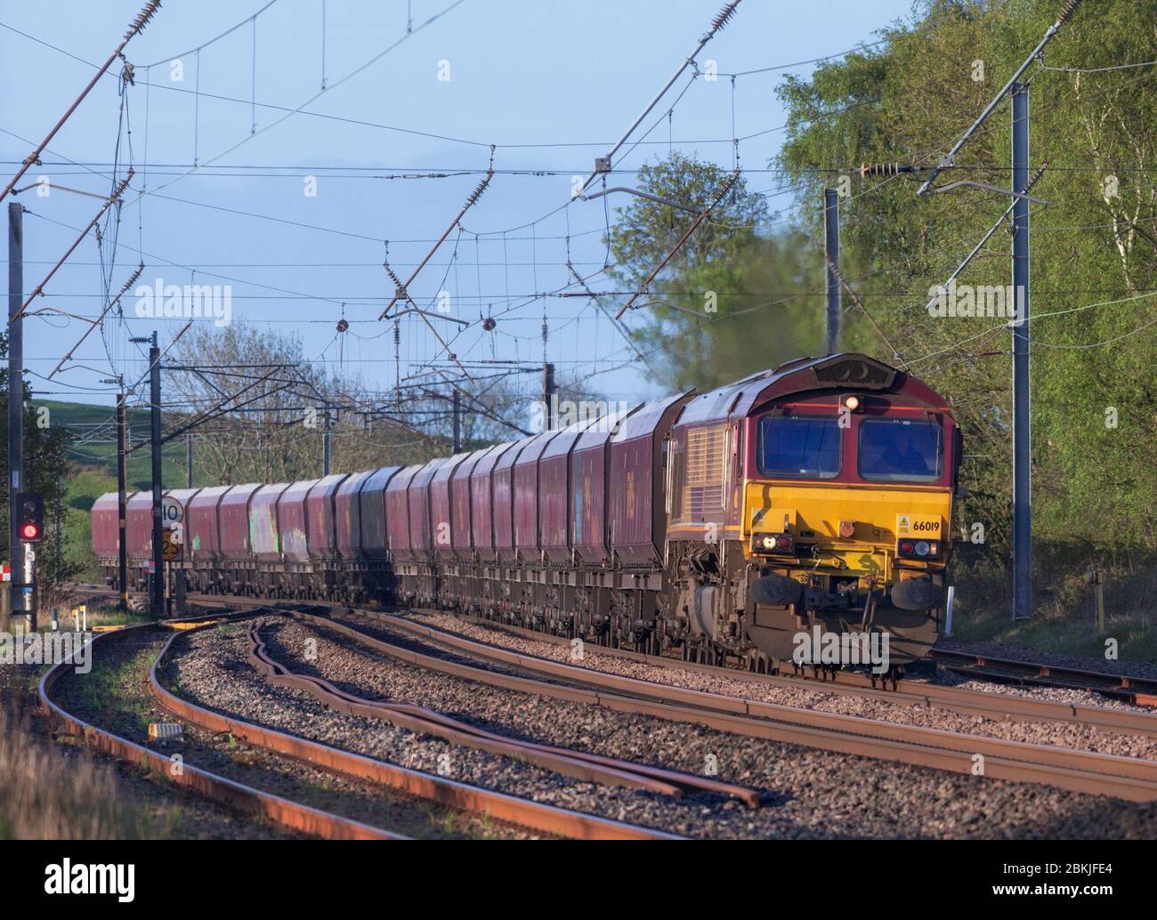 DB CARGO / EWS Baureihe 66 Diesellokomotive 66019 durch Oubeck vorbei an Schlingen auf der Westküste Hauptlinie mit einem Block Güterzug von HTA Waggons Stockfoto