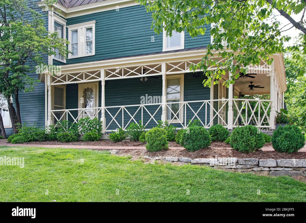 Rundum-Veranda, überdacht, altes Haus, blaue Abstellgleis, cremefarbene Zierleiste, grünes Gras, Pflanzungen, Maker's Mark Bourbon Distillery; National Historic Landmark, Ke Stockfoto