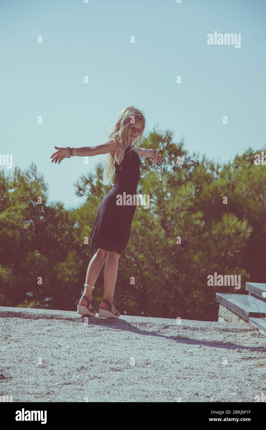 Nettes Kind in schwarzem Kleid tanzen im Sommer Tag gekleidet Stockfoto