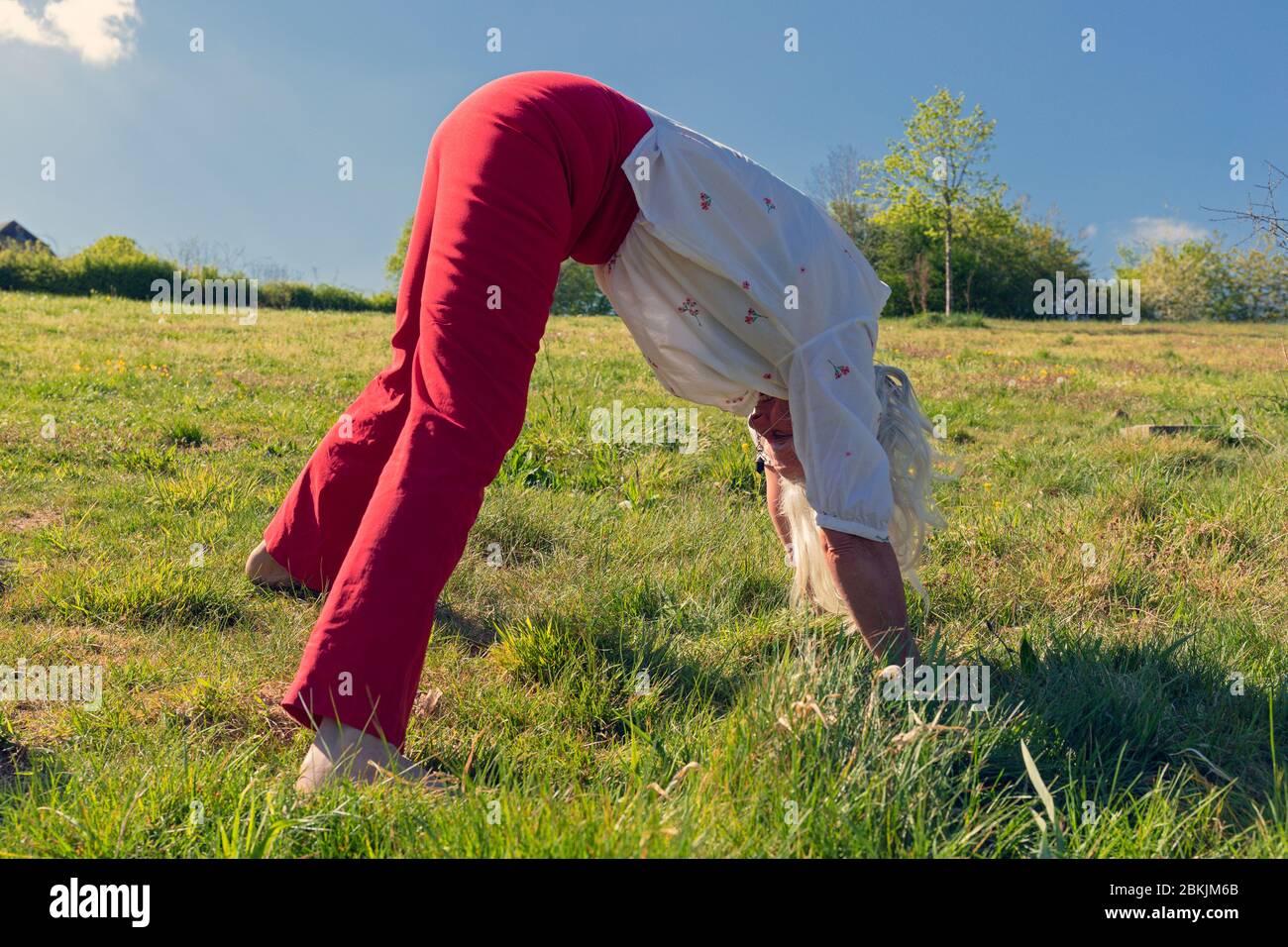 Europa, Luxemburg, Insenborn, attraktive ältere Frau, die die nach unten gerichtete Dog Yoga Position (Adho Mukha Shvanasana) Stockfoto