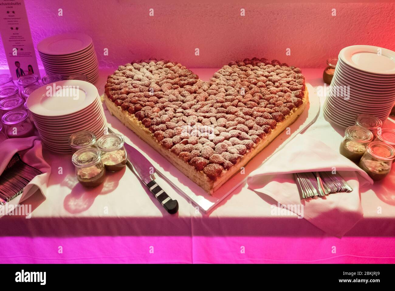 Wunderschöne herzförmige fruchtige Hochzeitstorte bei der Hochzeitsfeier Stockfoto