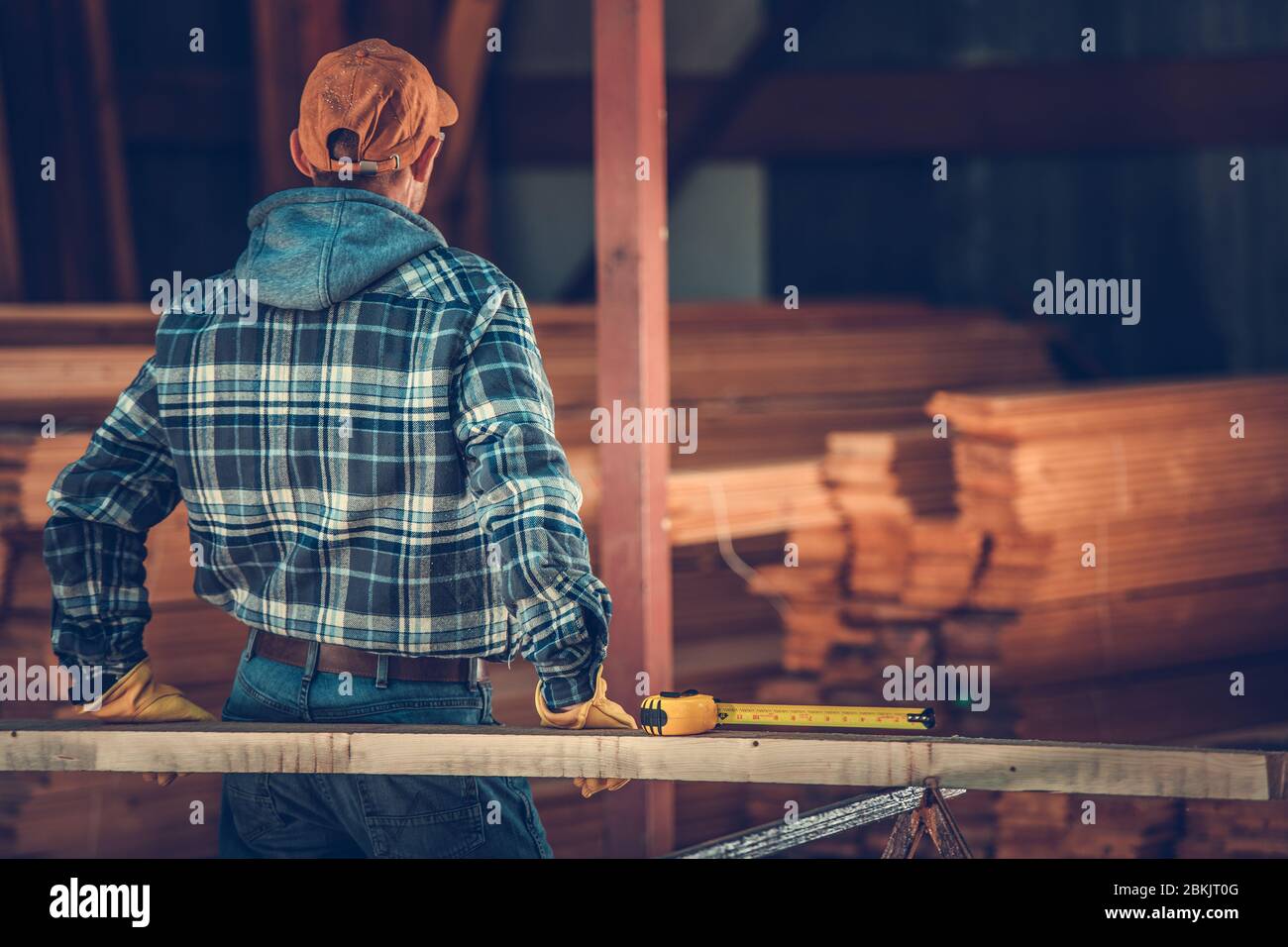 Mitte 30 's Male Carpenter Überprüfung Holzwerkstoff für Job benötigt. Stockfoto