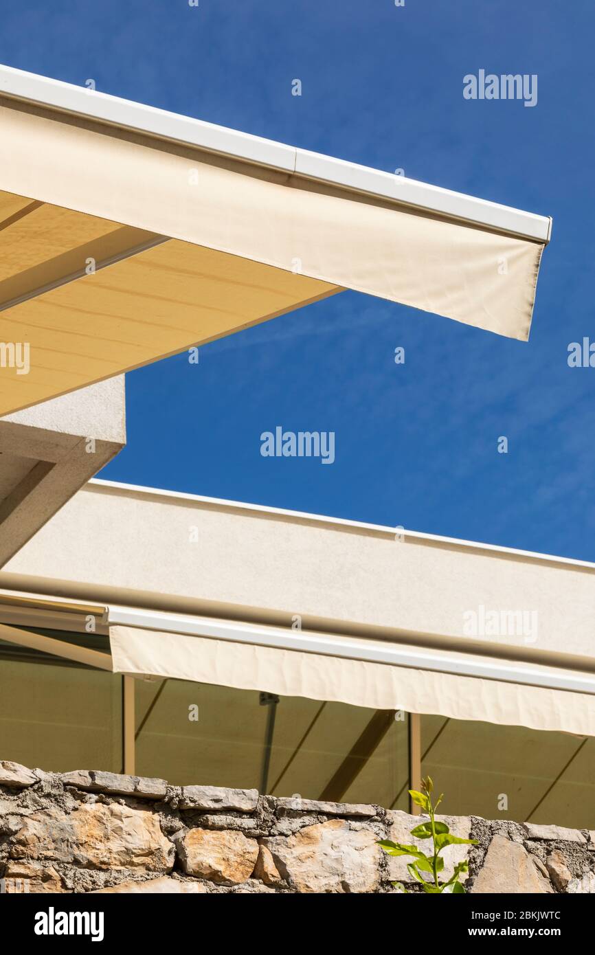 Eine gelbe Fenstermarkise in der Sommersonne in Bol, Dalmatien, Kroatien. Ein klarer blauer Himmel in der Nähe der Mittelmeerküste. Vertikale Aufnahme Stockfoto
