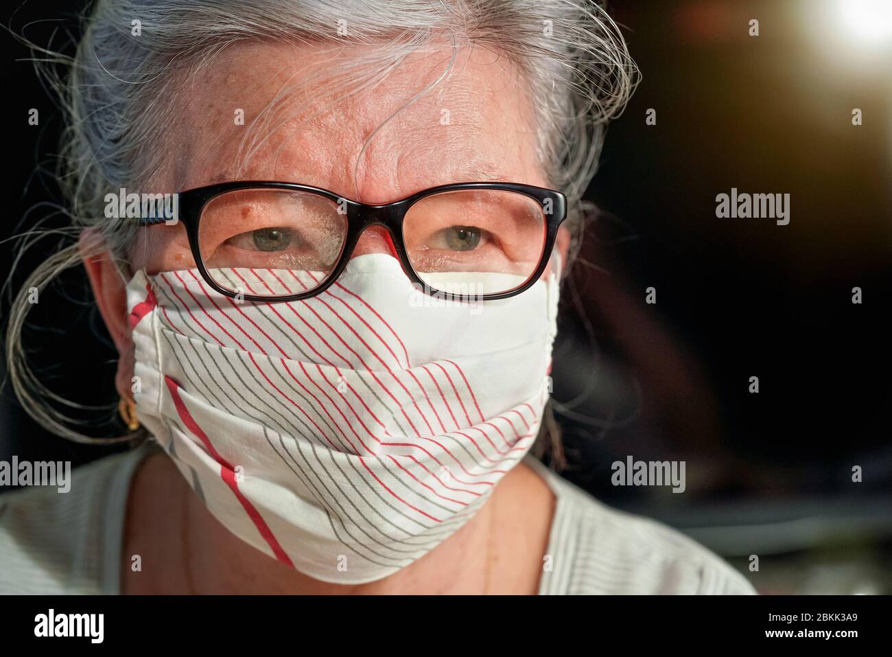 Ältere ältere Frau mit Brille trägt Hand gemacht Baumwollmund Nase Virus Gesichtsmaske. Coronavirus covid19 Konzept zur Prävention von Ausbrüchen Stockfoto