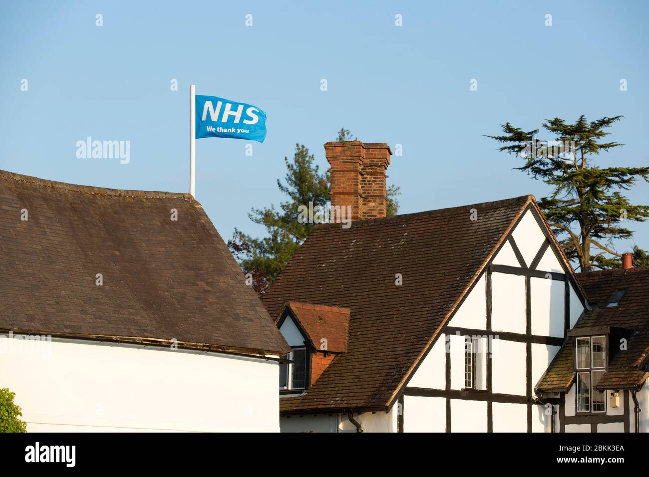 Eine Flagge, die den NHS unterstützt und über einem Landhaus in Claverdon, Warwickshire, Großbritannien, fliegt. Stockfoto