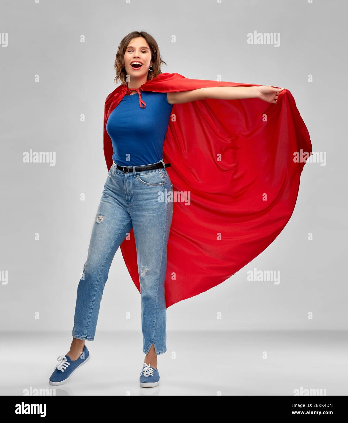 Glückliche Frau in roten Superhelden Umhang Stockfoto