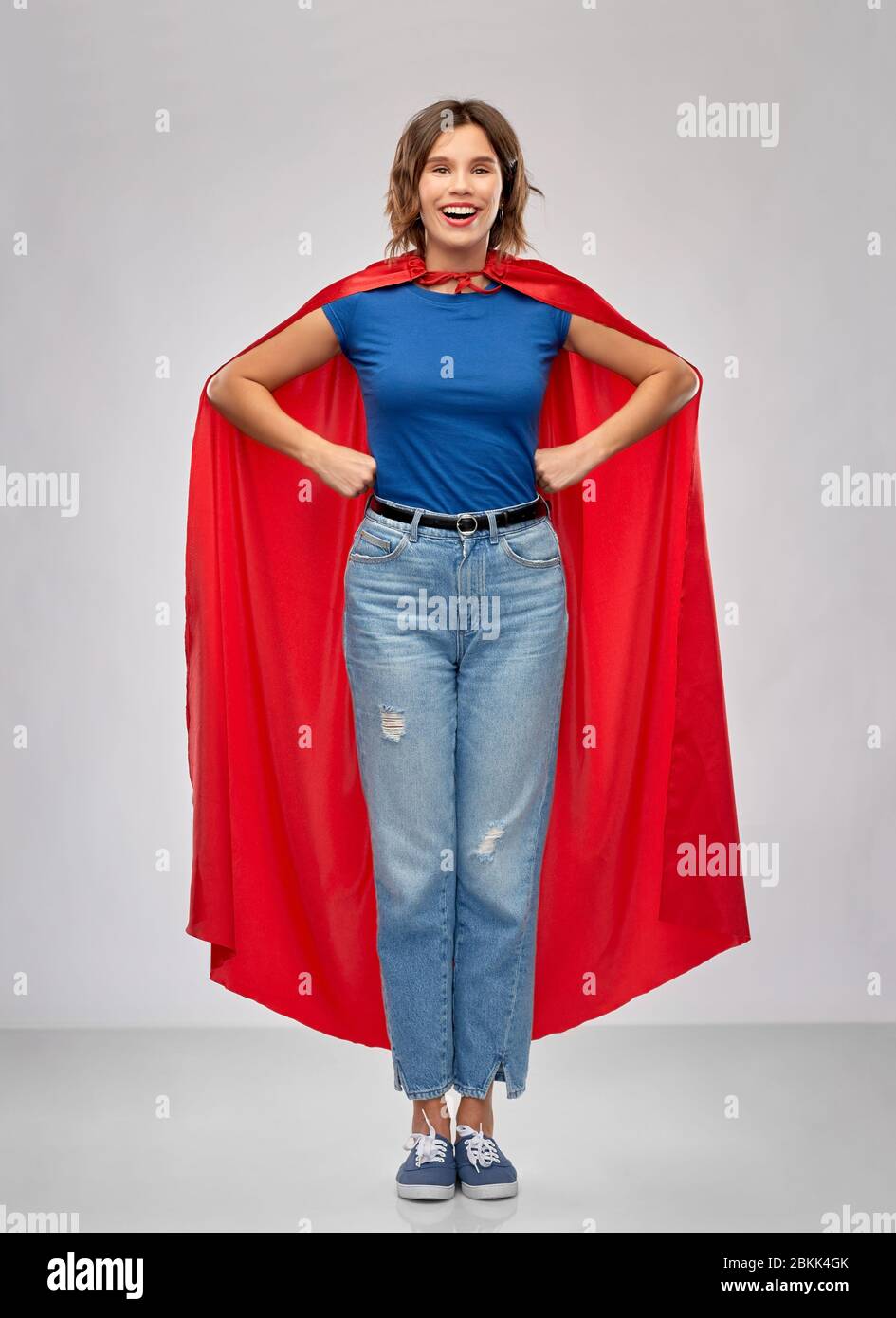 Glückliche Frau in roten Superhelden Umhang Stockfoto