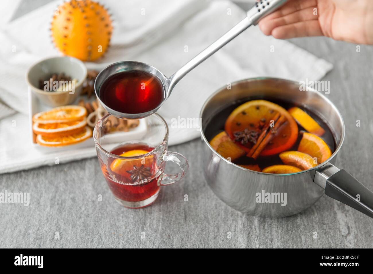 Hand mit Schöpfkelle Gießen heißen Glühwein zu Glas Stockfoto